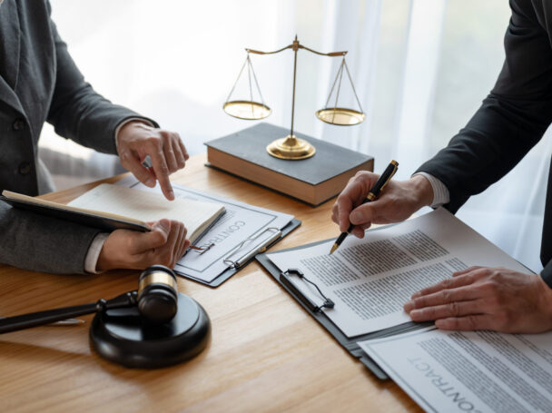 Lawyer, legal advisor, businessman brainstorming information on agreement details Business contracts in legal processing books for accuracy in contract documents. joint financial investment.